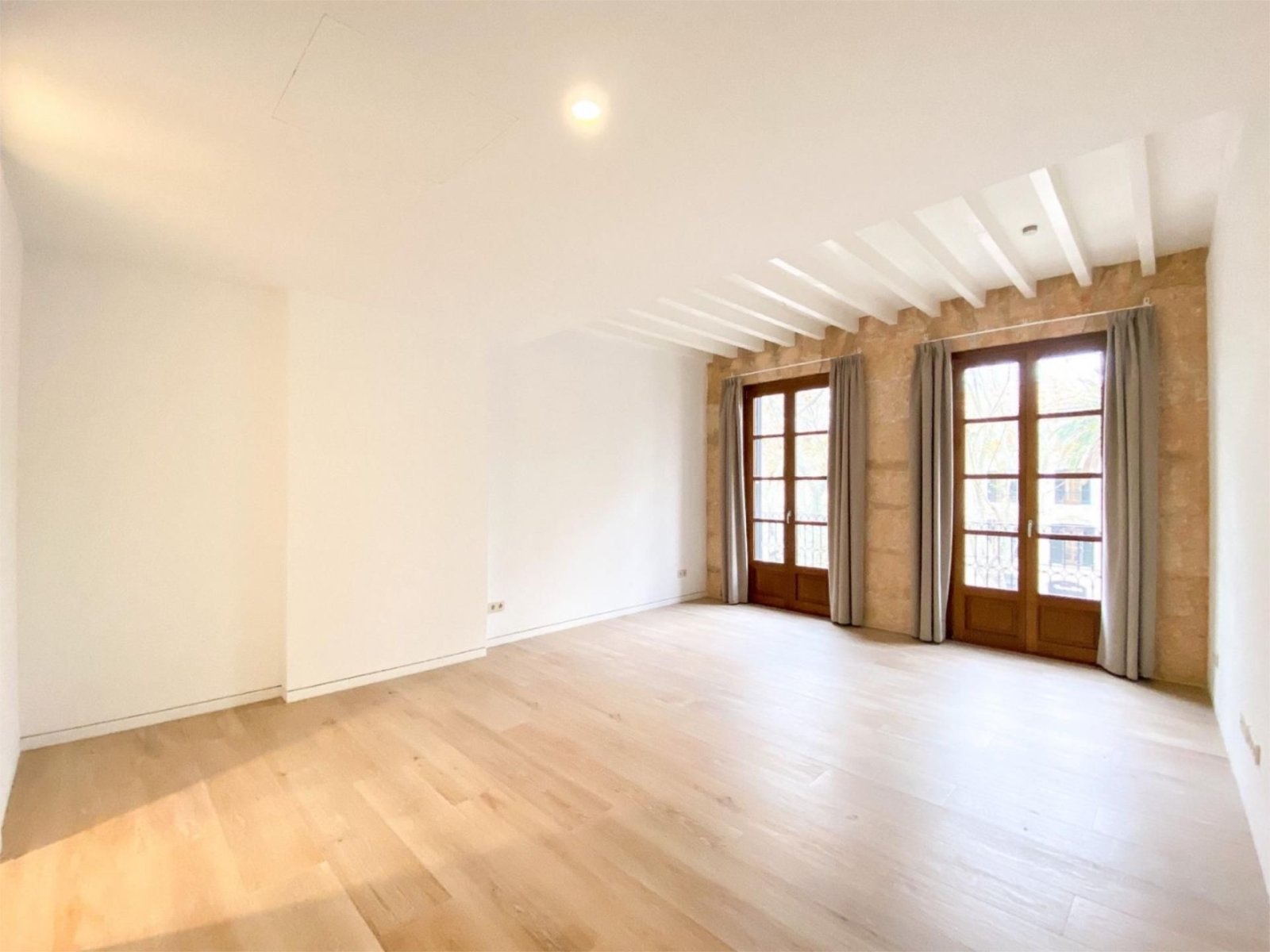 Helles Wohnzimmer mit Dachflächenfenstern und direktem Zugang zur Terrasse