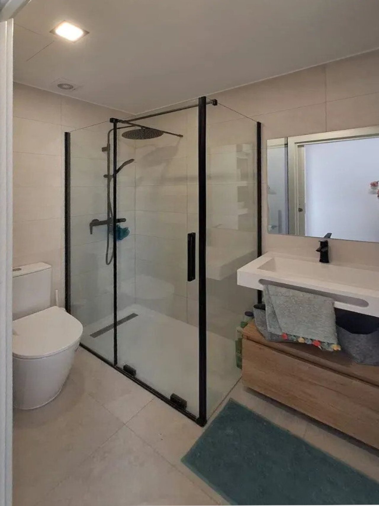 Modernes Badezimmer mit bodengleicher Dusche und großflächigem Spiegel Modernes Badezimmer mit bodengleicher Dusche und großflächigem Spiegel