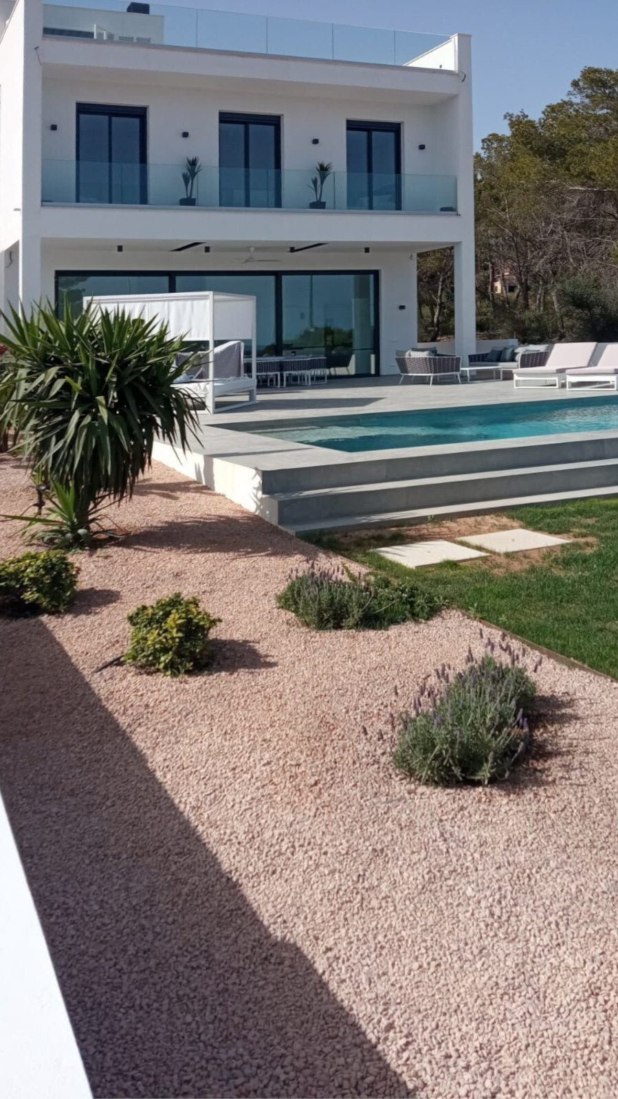 Moderne Außenanlage mit beheiztem Pool, erhöhter Poolterrasse und pflegeleichtem Gartendesign Moderne Außenanlage mit beheiztem Pool, erhöhter Poolterrasse und pflegeleichtem Gartendesign