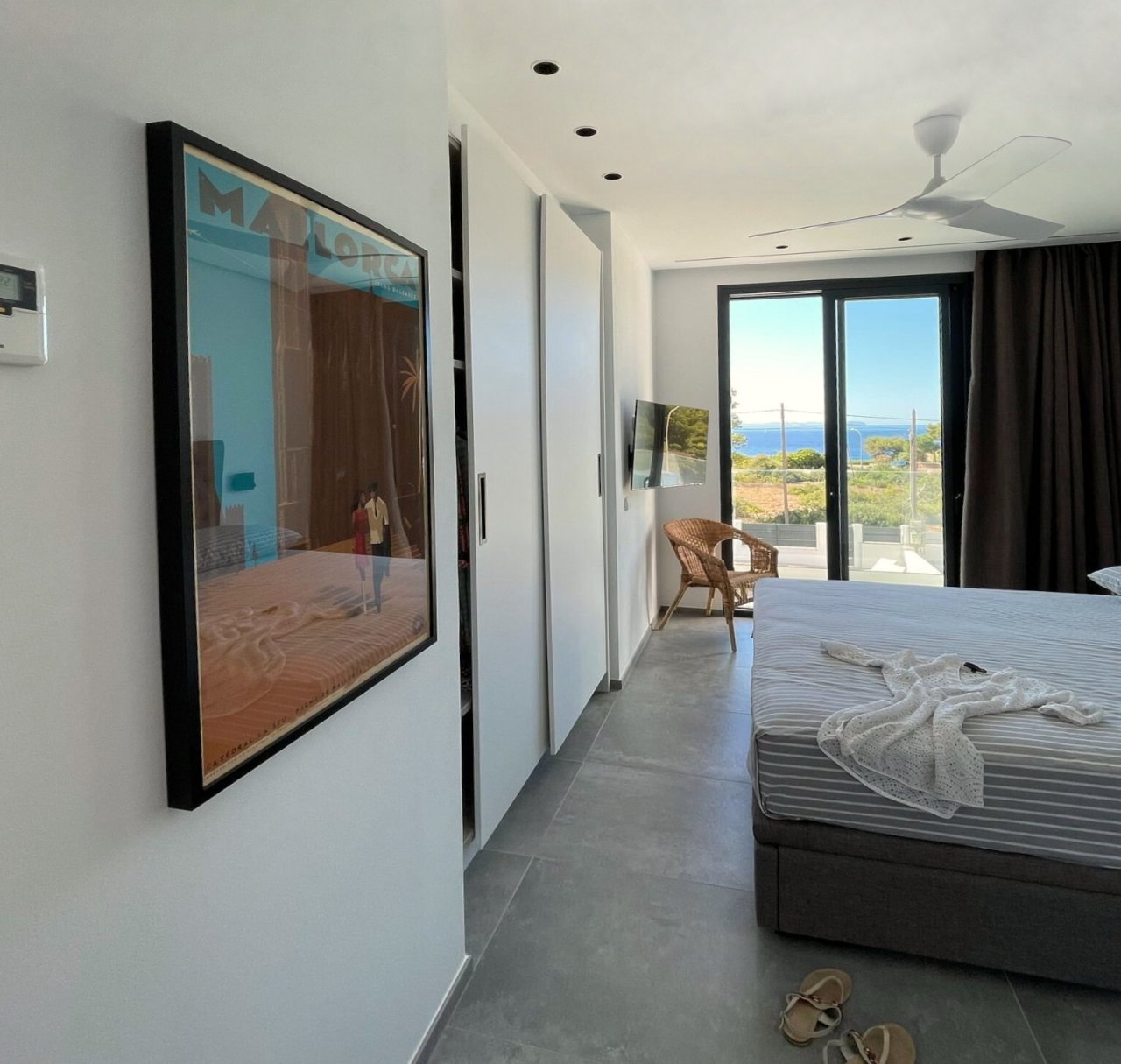 Hauptschlafzimmer mit offener Raumgestaltung, begehbarem Kleiderschrank und direktem Zugang zur privaten Terrasse mit Meerblick Hauptschlafzimmer mit offener Raumgestaltung, begehbarem Kleiderschrank und direktem Zugang zur privaten Terrasse mit Meerblick