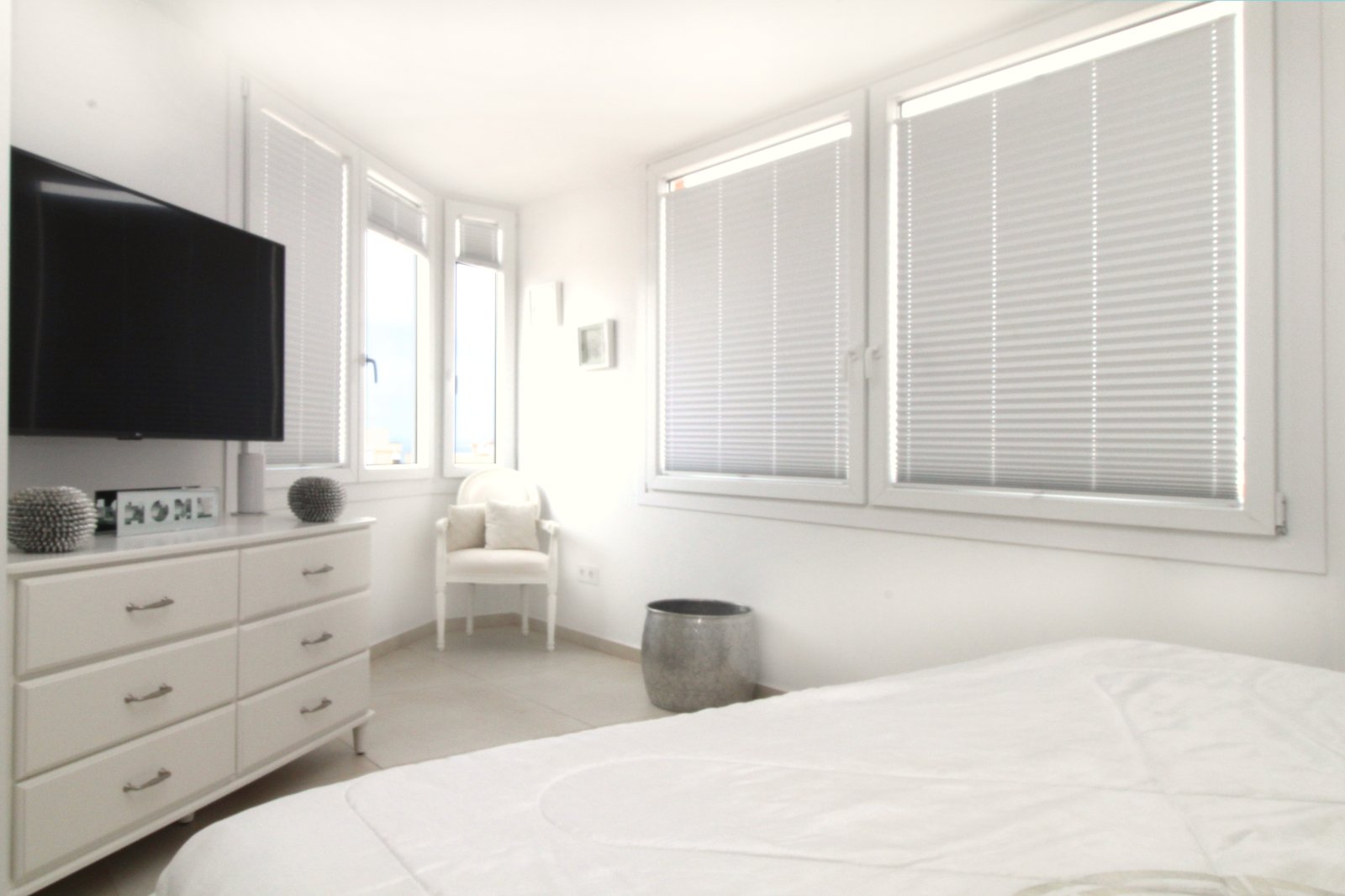 Helles Schlafzimmer mit großflächigen Fenstern und praktischen Stauraummöglichkeiten