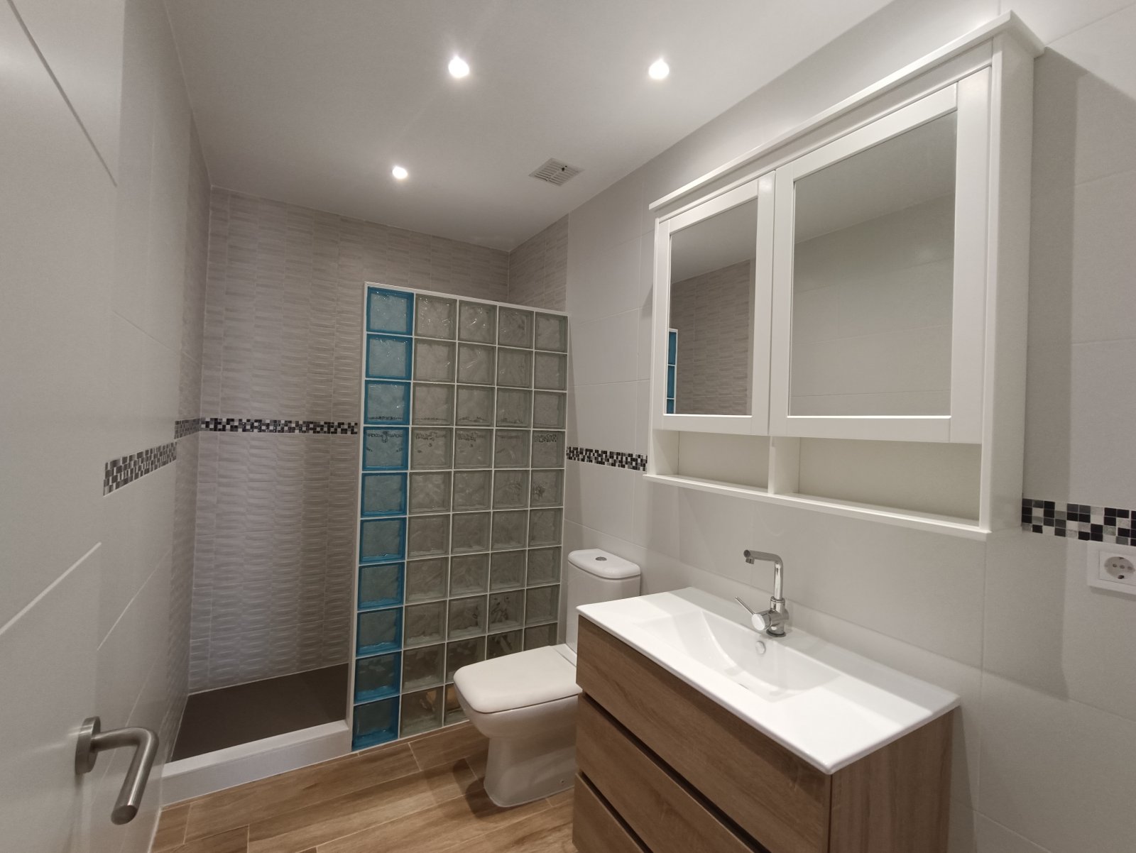 Modernes Badezimmer mit bodengleicher Dusche und beleuchteter Spiegelwand – Praktischer Nassbereich mit hochwertiger Ausstattung und intelligenten Stauraumlösungen Modernes Badezimmer mit bodengleicher Dusche und beleuchteter Spiegelwand – Praktischer Nassbereich mit hochwertiger Ausstattung und intelligenten Stauraumlösungen