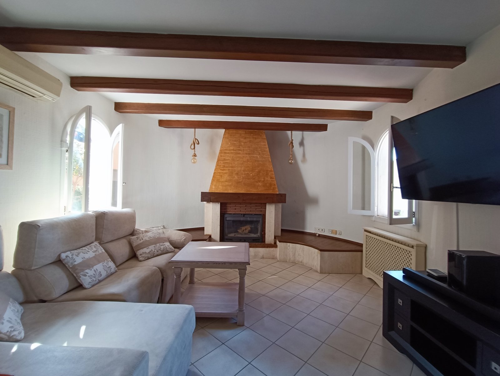 Wohnzimmer mit imposantem Kaminofen und charaktervollen Deckenbalken – Atmosphärischer Wohnbereich mit Raumhöhe und Struktur Wohnzimmer mit imposantem Kaminofen und charaktervollen Deckenbalken – Atmosphärischer Wohnbereich mit Raumhöhe und Struktur
