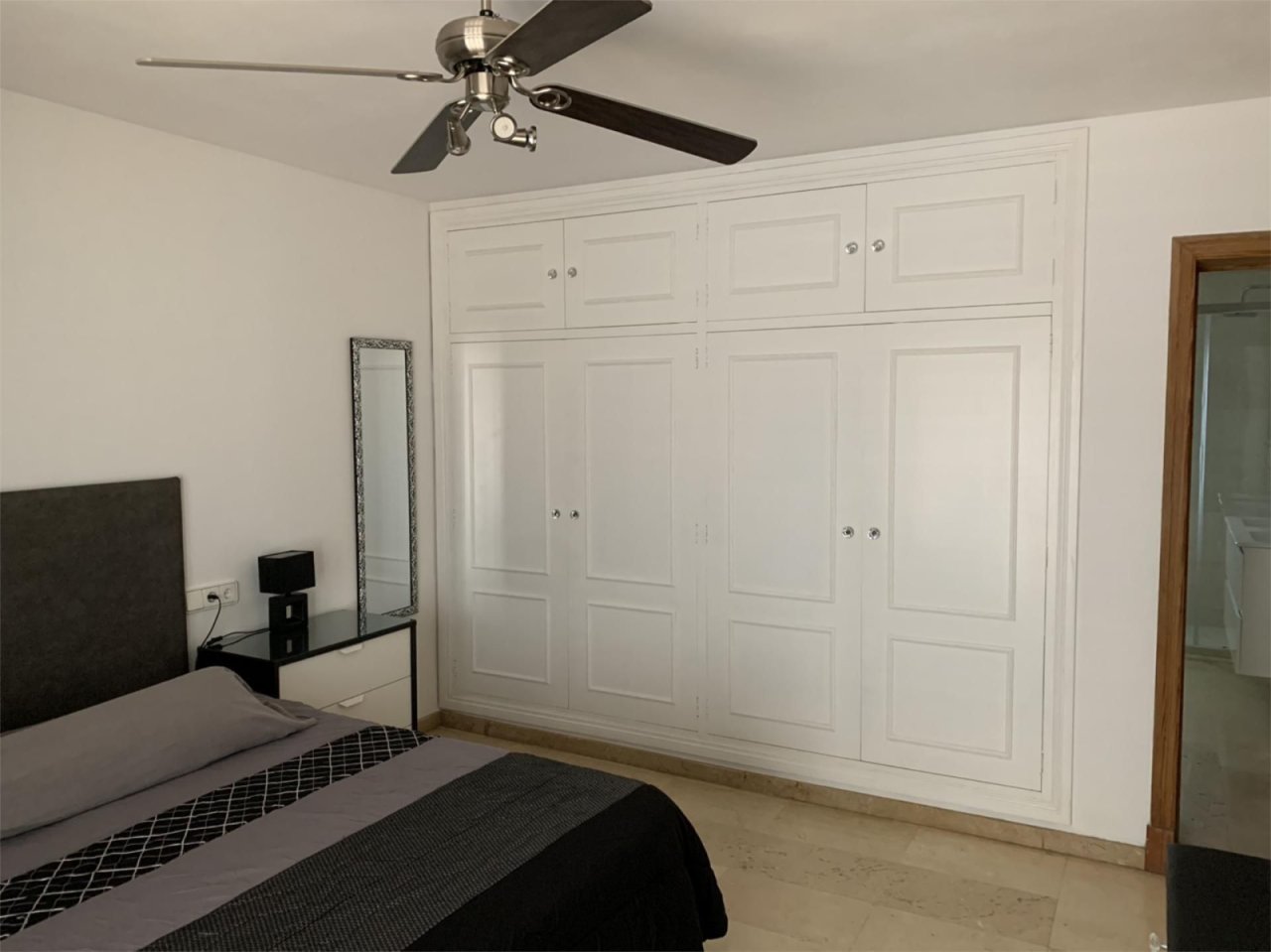 Schlafzimmer mit umfangreicher Schrankwandanlage und Deckenventilator Schlafzimmer mit umfangreicher Schrankwandanlage und Deckenventilator