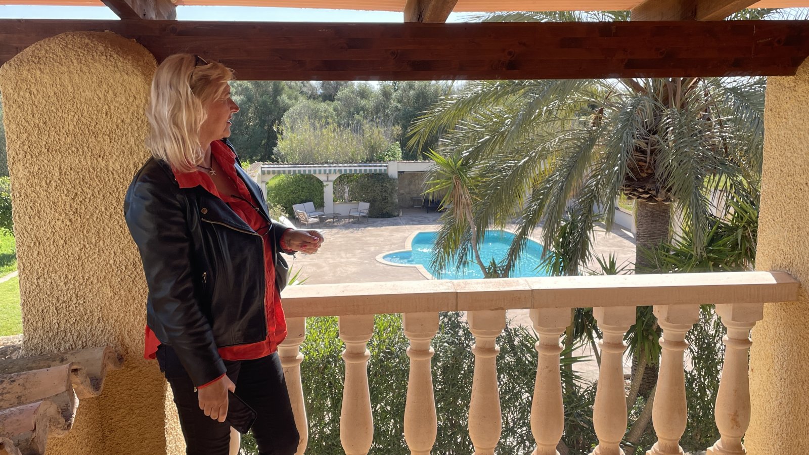 Überdachte Loggia mit Holzbalkenstruktur und freiem Poolblick