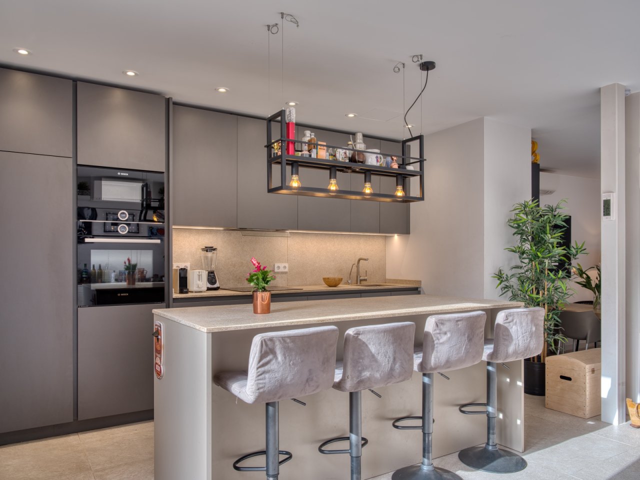 Moderne Küche mit zentraler Kochinsel und integrierter Esstheke Moderne Küche mit zentraler Kochinsel und integrierter Esstheke