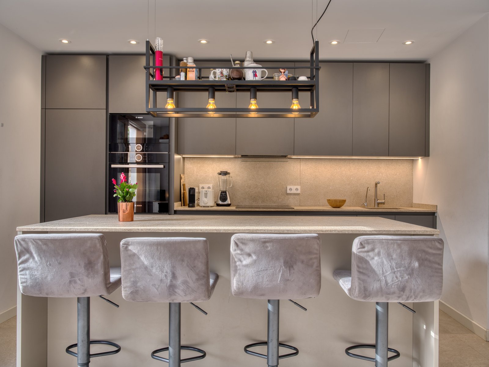 Moderne Designerküche mit zentraler Kochinsel, hochwertigen Einbaugeräten und funktionaler Arbeitsfläche Moderne Designerküche mit zentraler Kochinsel, hochwertigen Einbaugeräten und funktionaler Arbeitsfläche