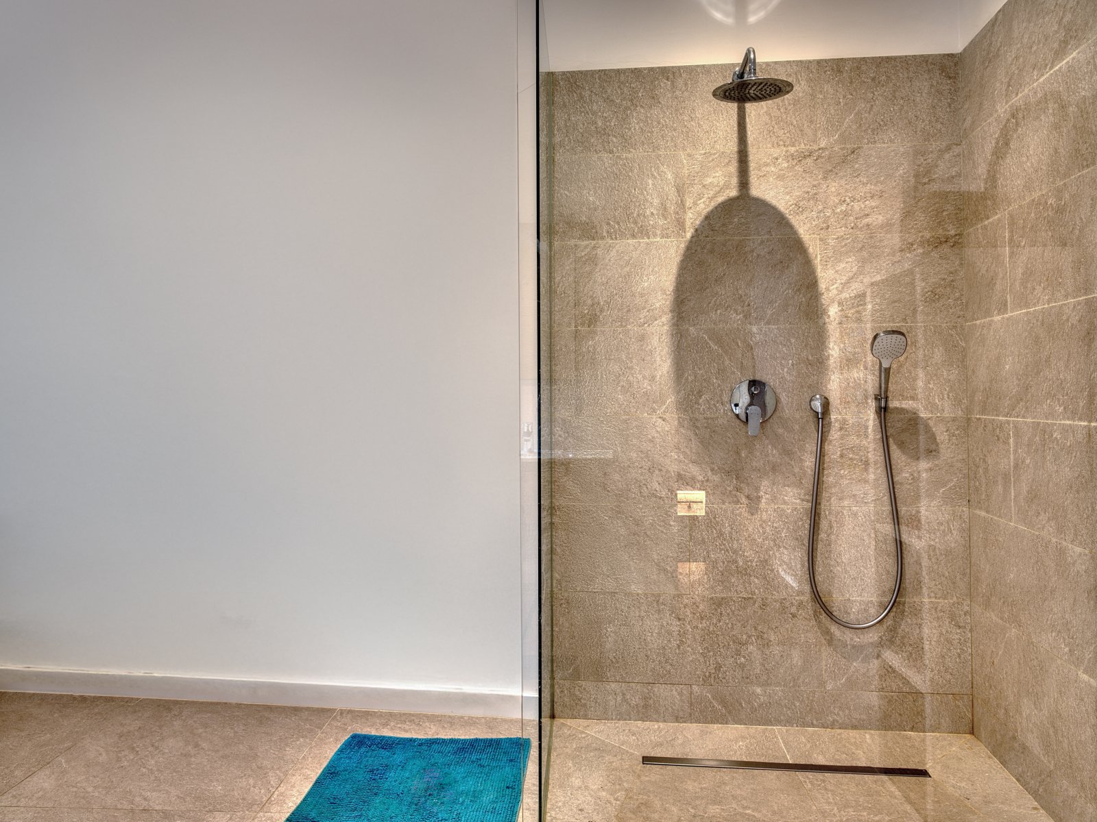 Luxuriöses Duschbad mit ebenerdiger Regendusche und hochwertiger Sanitärausstattung Luxuriöses Duschbad mit ebenerdiger Regendusche und hochwertiger Sanitärausstattung