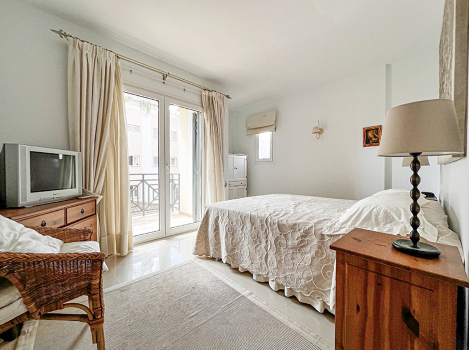 Helles Hauptschlafzimmer mit französischen Balkontüren und Klimaanlage