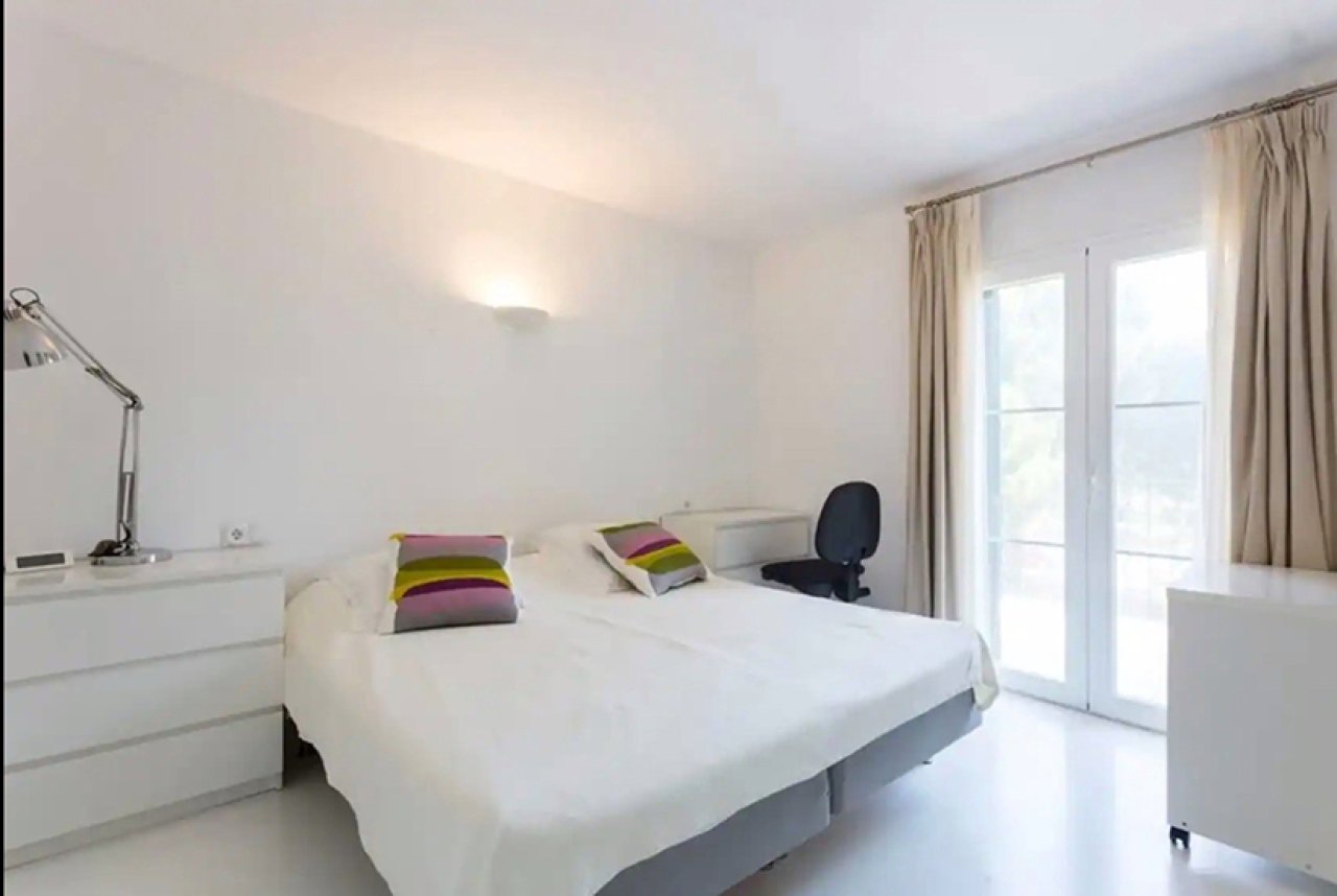 Helles Schlafzimmer mit direktem Terrassenzugang und großflächigen Fenstern