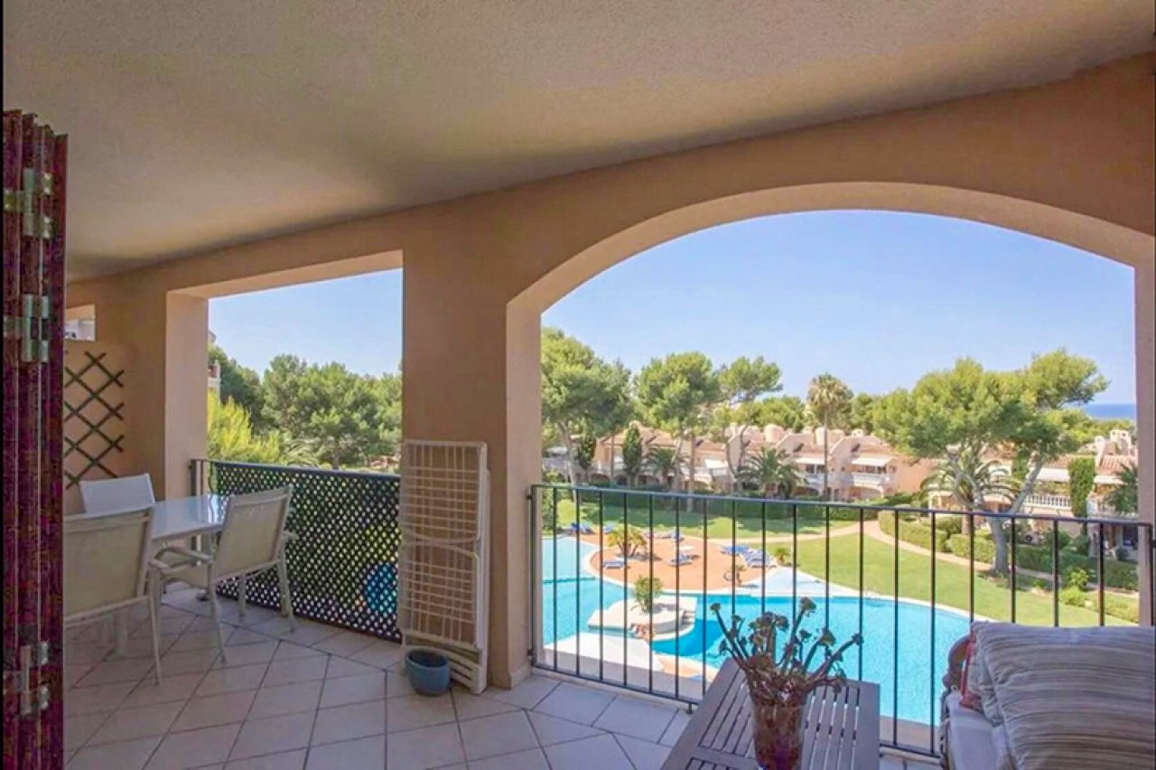 Großzügiger Balkon mit Poolblick und eleganten Rundbogenöffnungen