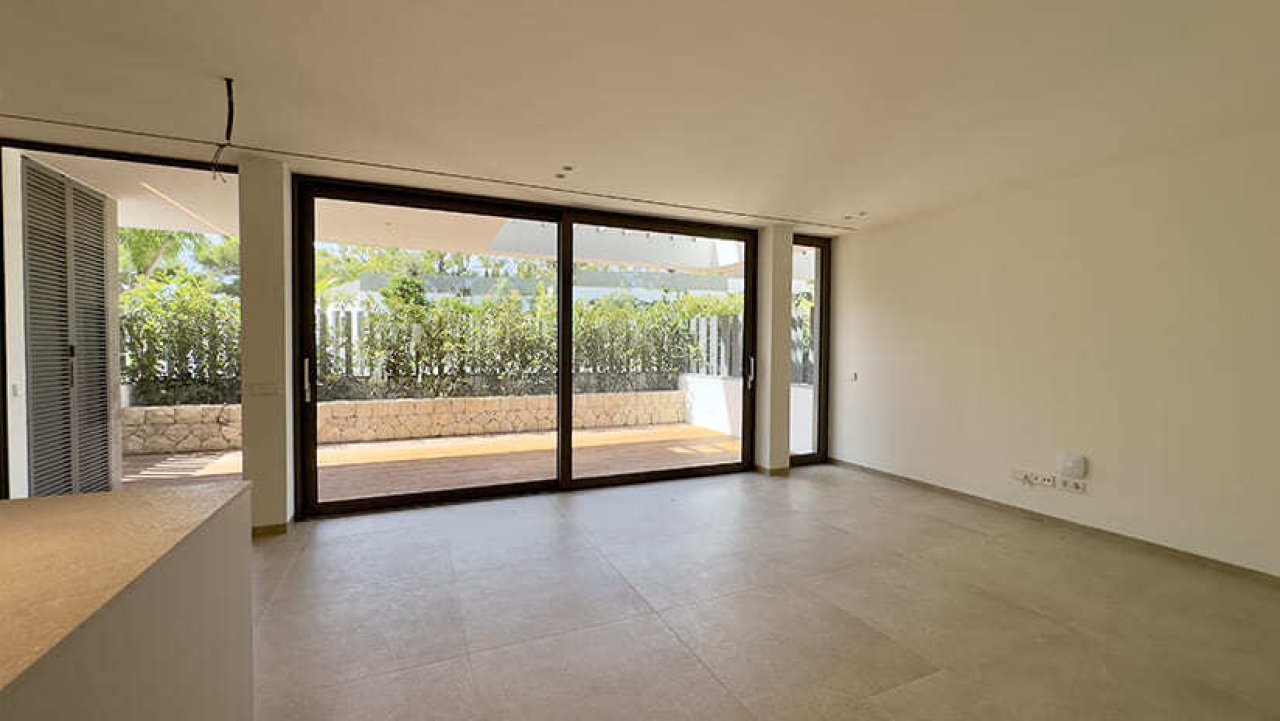 Helles Wohnzimmer mit großflächigen Schiebetüren und freiem Blick zur Terrasse