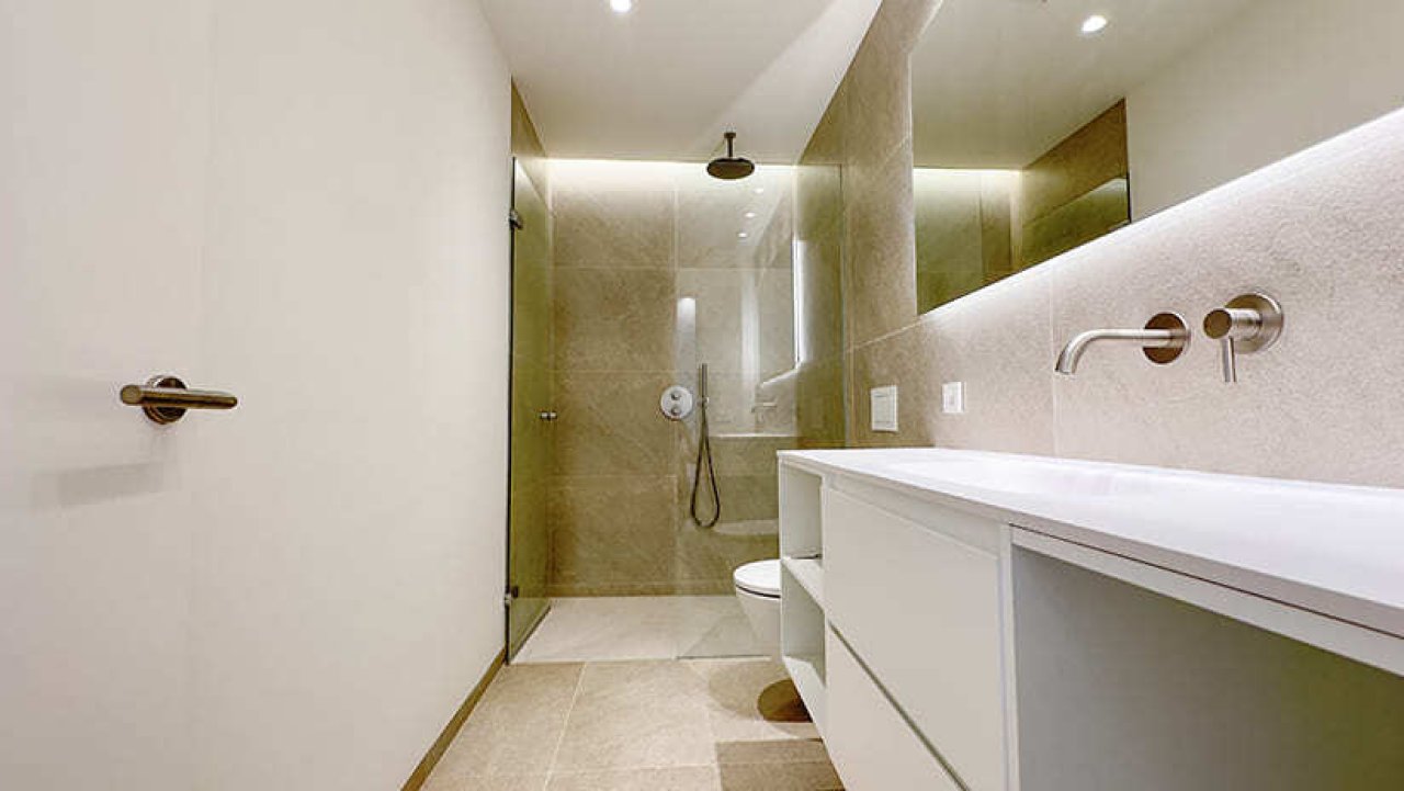 Modernes Badezimmer mit bodengleicher Dusche und großflächigen Spiegeln
