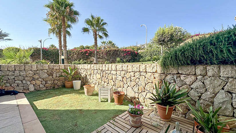Privater Gartenbereich mit massiver Natursteinmauer und umfassender Begrünung