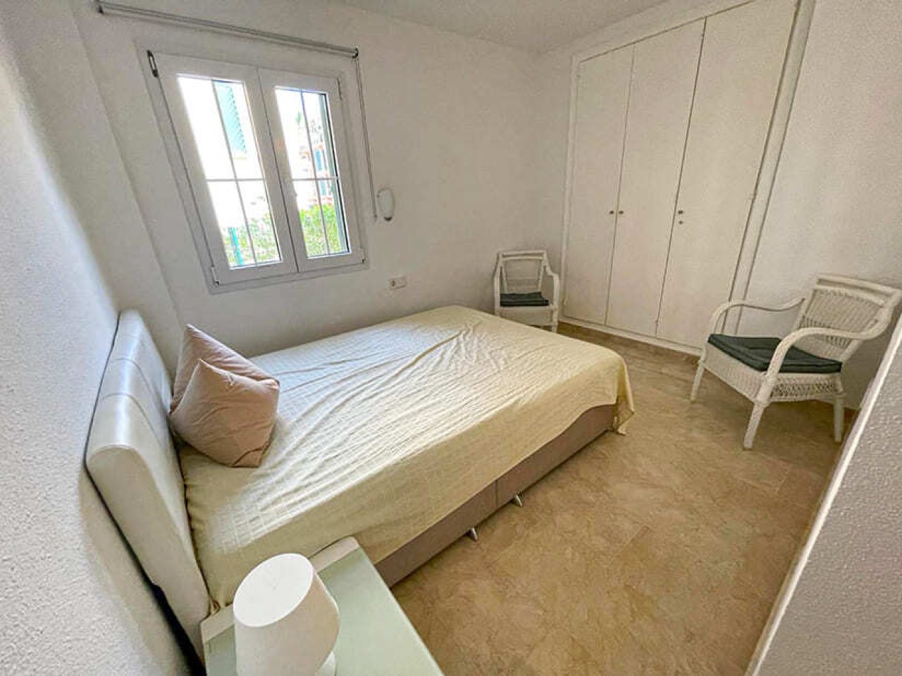 Helles Schlafzimmer mit praktischen Einbauschränken und Balkonzugang