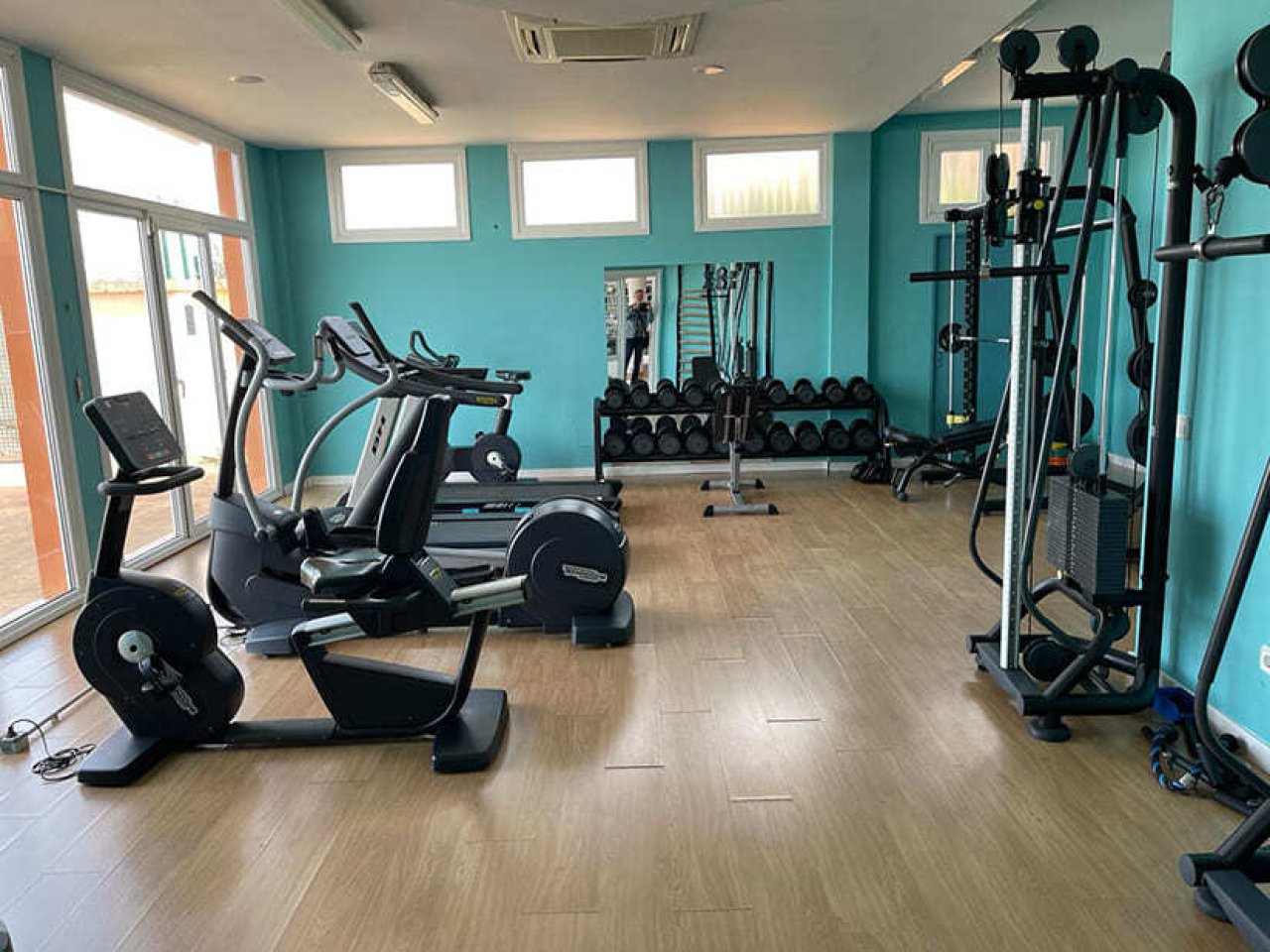 Moderner Fitnessbereich mit optimaler Raumnutzung und großflächiger Fensterfront