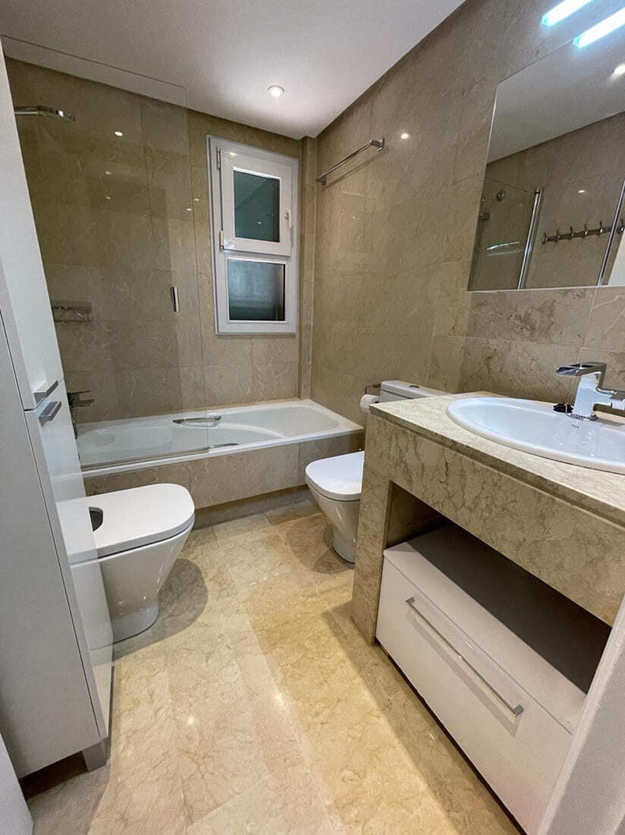 Modernes Badezimmer mit bodengleicher Dusche und hochwertigem Natursteinbelag