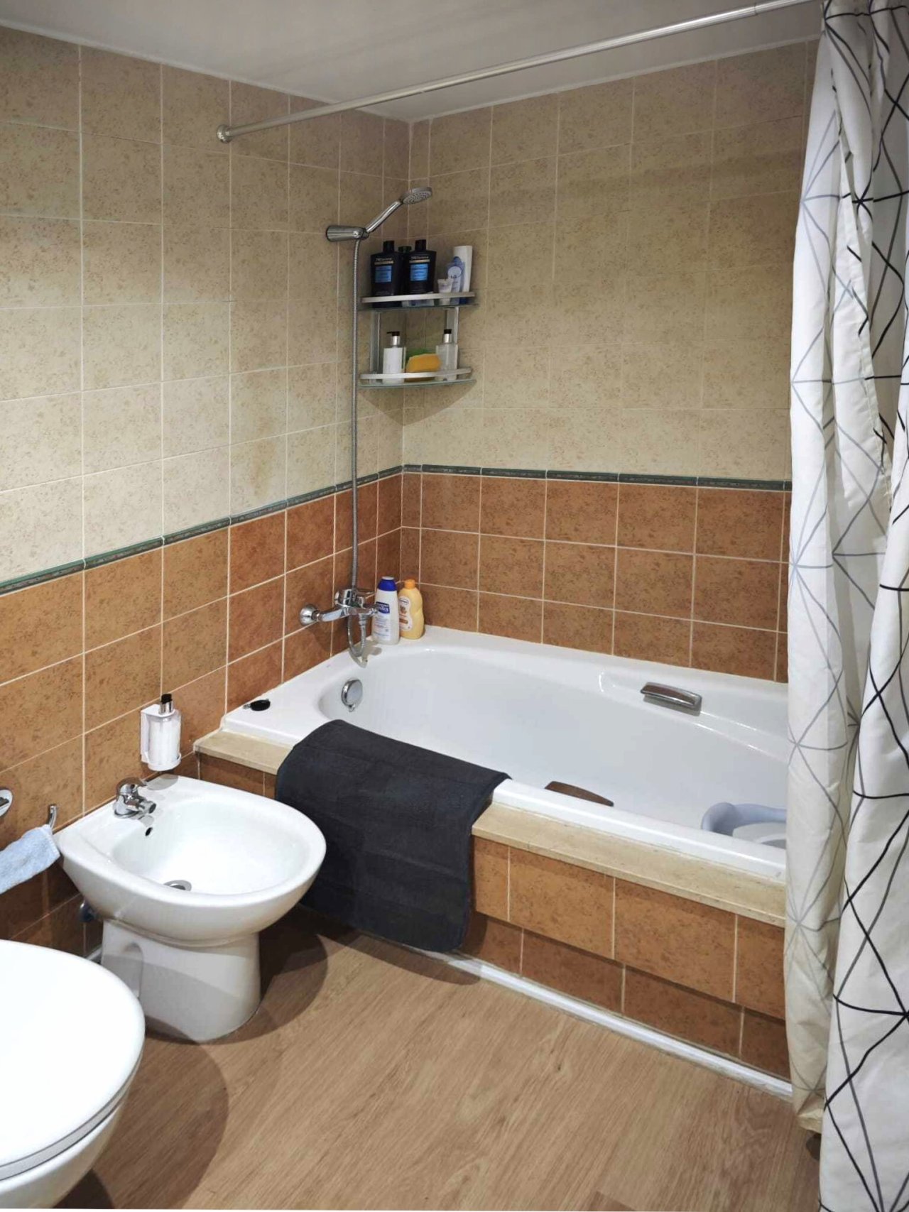 Funktionales Badezimmer mit Wanne, Dusche und praktischen Ablageflächen