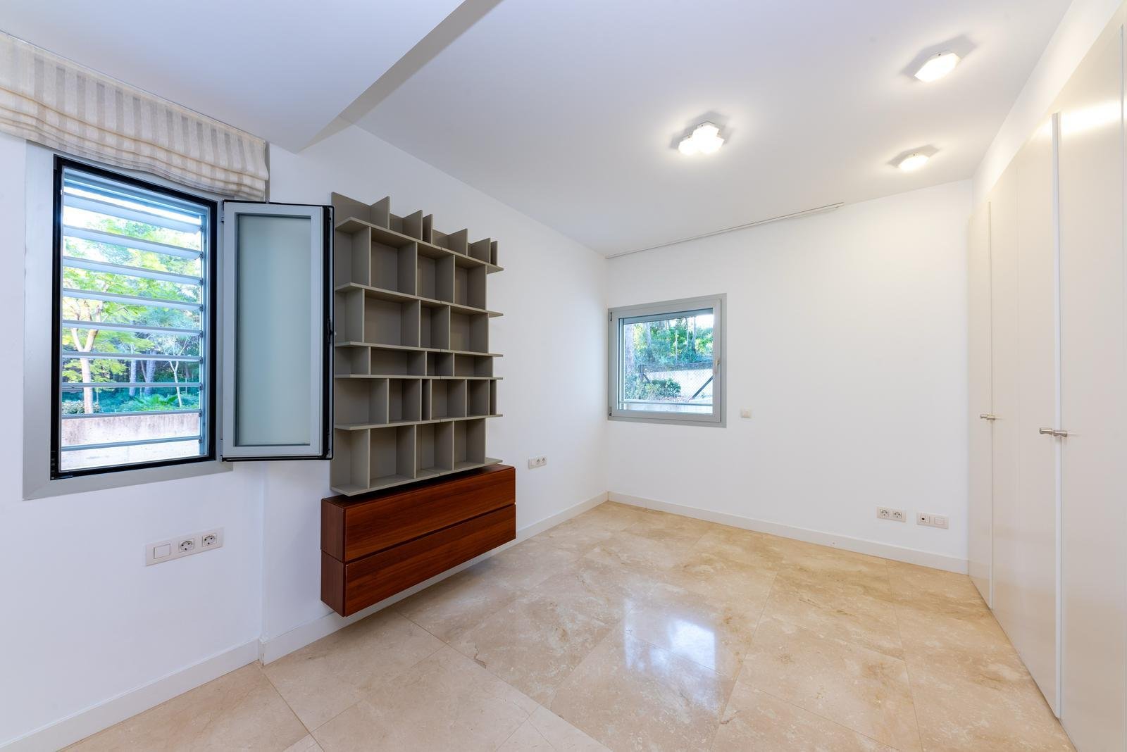 Modernes Arbeitszimmer mit integriertem Regalsystem und Tageslichtfenstern Modernes Arbeitszimmer mit integriertem Regalsystem und Tageslichtfenstern