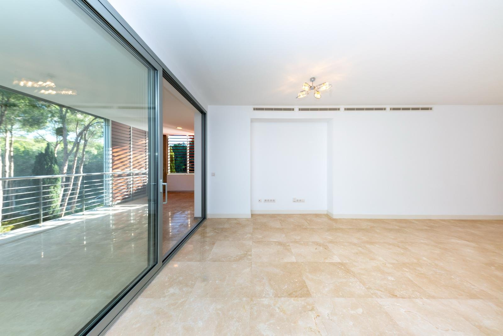 Wohnbereich mit raumhohen Glasschiebetüren und direktem Terrassenausgang Wohnbereich mit raumhohen Glasschiebetüren und direktem Terrassenausgang
