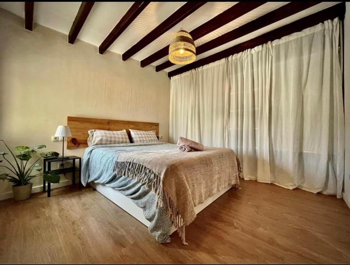 Schlafzimmer mit charaktervoller Deckengestaltung und großflächigen Fenstern Schlafzimmer mit charaktervoller Deckengestaltung und großflächigen Fenstern