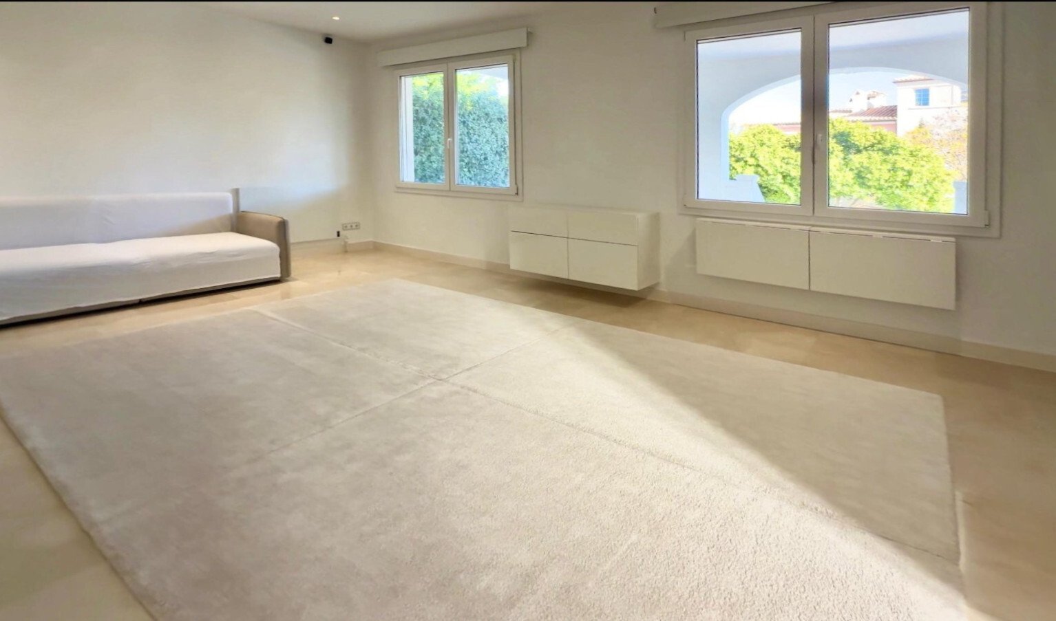 Helles Schlafzimmer mit großflächiger Fensterfront und intelligenter Stauraum-Integration
