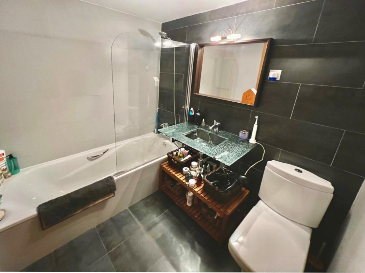 Elegantes Badezimmer mit begehbarer Dusche, hochwertiger Steinarbeitsplatte und durchdachtem Stauraum