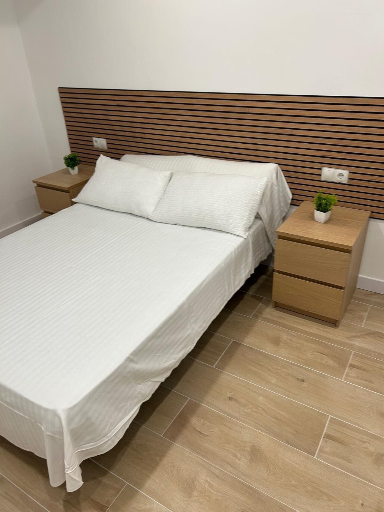 Komfortables Schlafzimmer mit integriertem Kopfteil und praktischen Steckdosen im Kopfbereich Komfortables Schlafzimmer mit integriertem Kopfteil und praktischen Steckdosen im Kopfbereich