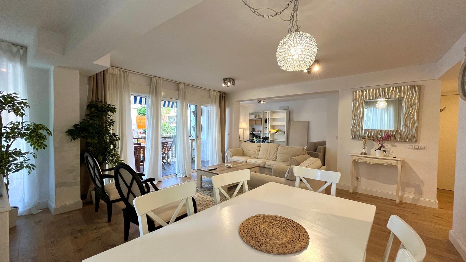 Offenes Wohn- und Esszimmer mit hohen Decken und großzügigen Glasschiebetüren zum Balkon Offenes Wohn- und Esszimmer mit hohen Decken und großzügigen Glasschiebetüren zum Balkon