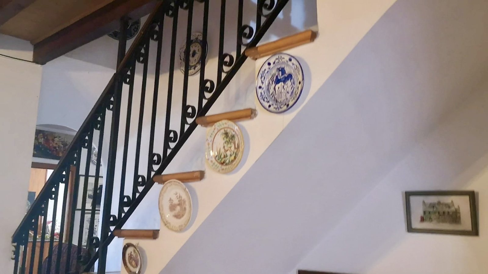 Elegante Treppe mit schmiedeeisernem Geländer und großzügigen Holzstufen Elegante Treppe mit schmiedeeisernem Geländer und großzügigen Holzstufen