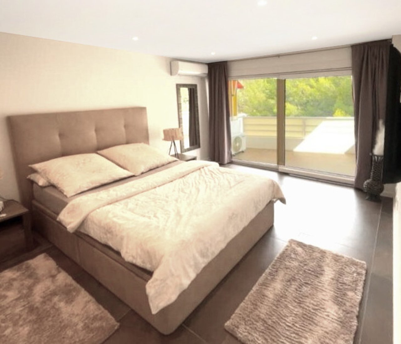 Hauptschlafzimmer mit direktem Terrassenzugang und großflächiger Verglasung