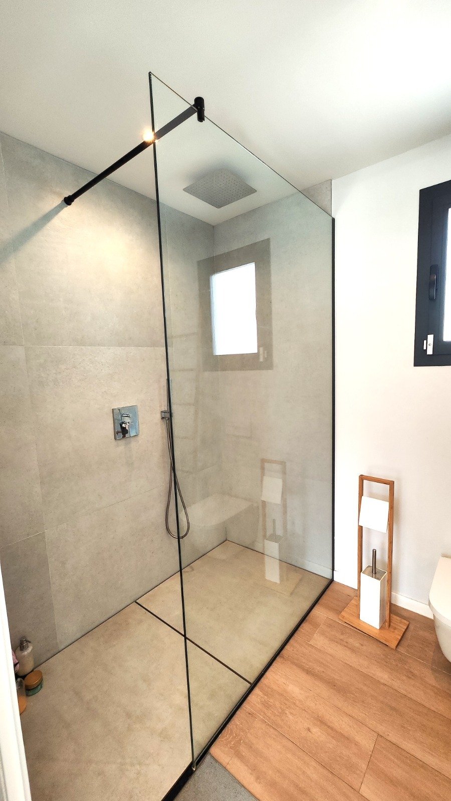 Luxuriöse Dusche mit bodengleichem Einstieg und rahmenloser Glasabtrennung Luxuriöse Dusche mit bodengleichem Einstieg und rahmenloser Glasabtrennung