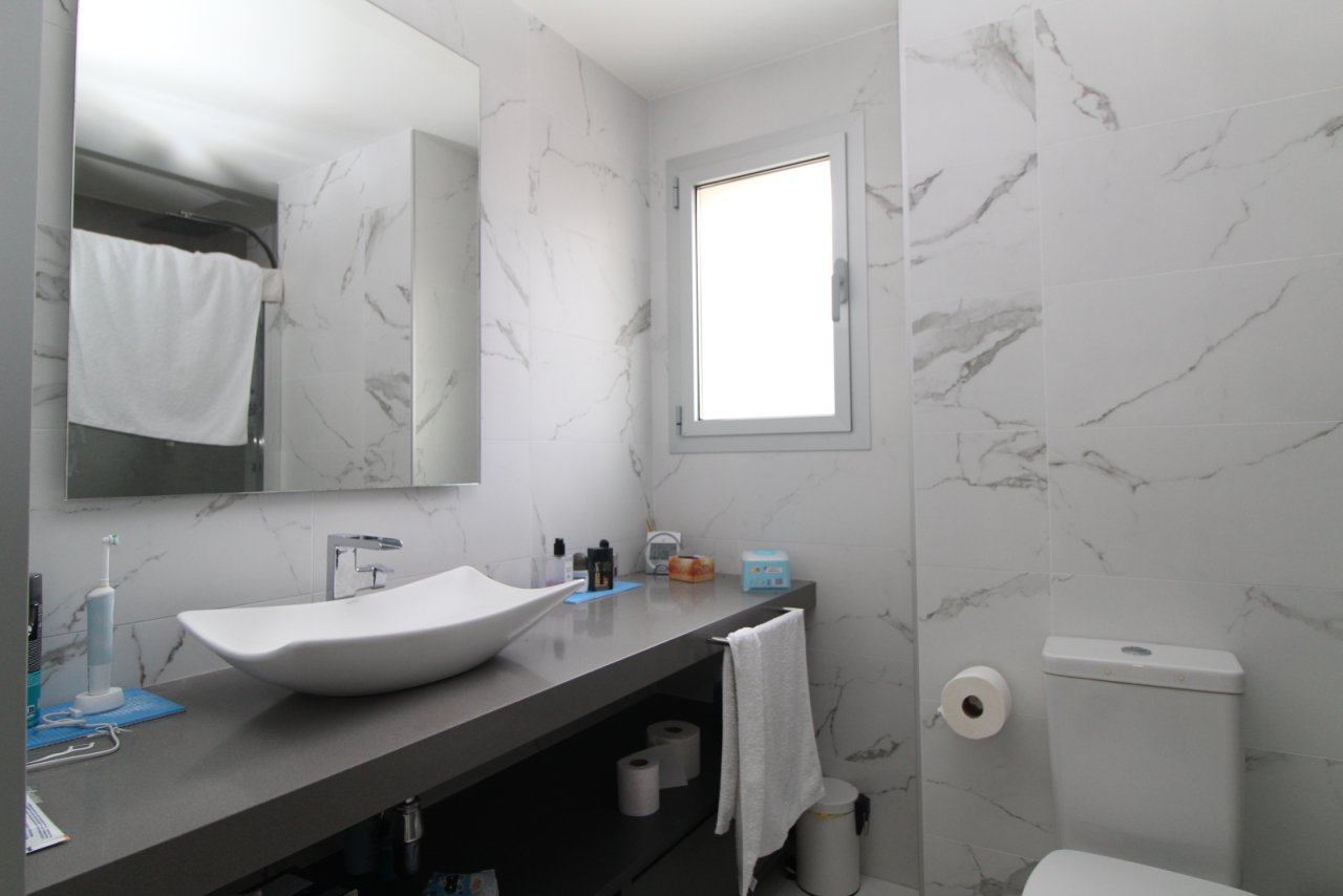 Modernes Badezimmer mit Marmor-Wandverkleidung und hochwertiger Sanitärausstattung
