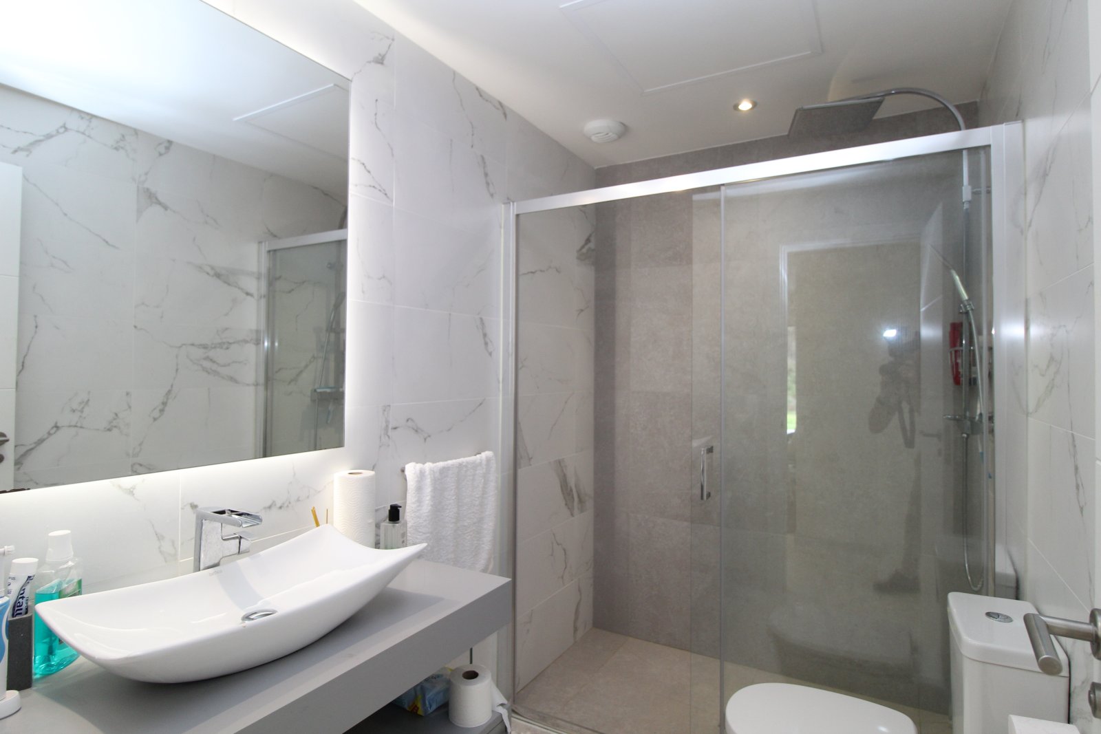 Edles Badezimmer mit begehbarer Dusche und beleuchteter Spiegelfront