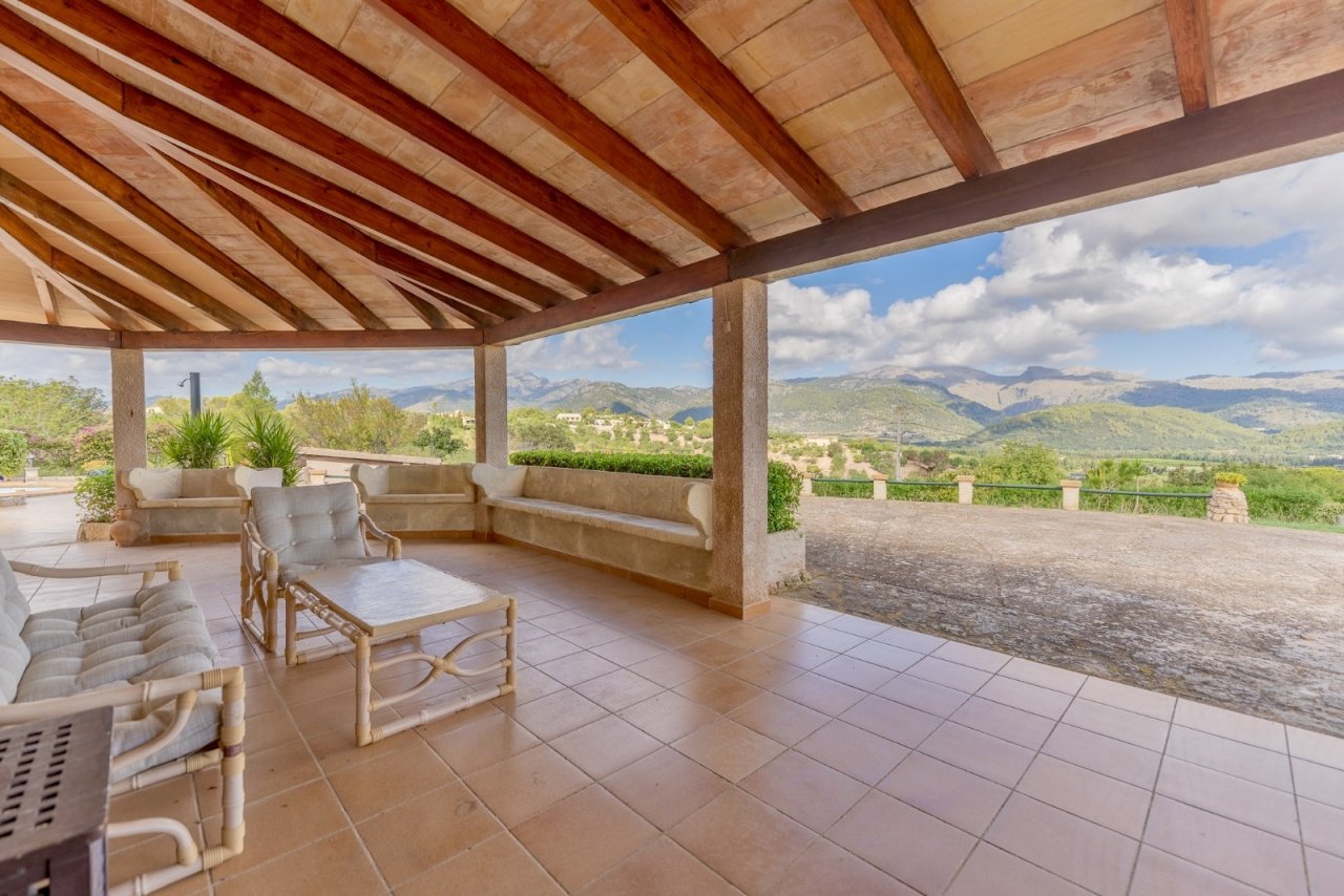 Überdachte Terrasse mit Holzbalkendecke und Panoramablick auf die Berglandschaft Überdachte Terrasse mit Holzbalkendecke und Panoramablick auf die Berglandschaft