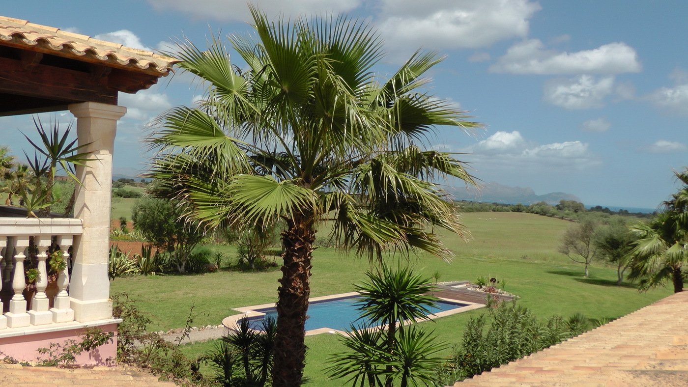 Panoramablick vom Terrassenbereich über Swimmingpool und Parklandschaft
