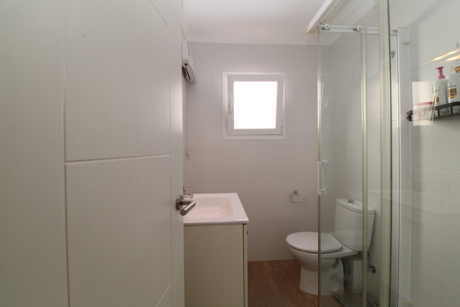 Funktionales Badezimmer mit modernem Duschbereich und hellem Fenster Funktionales Badezimmer mit modernem Duschbereich und hellem Fenster