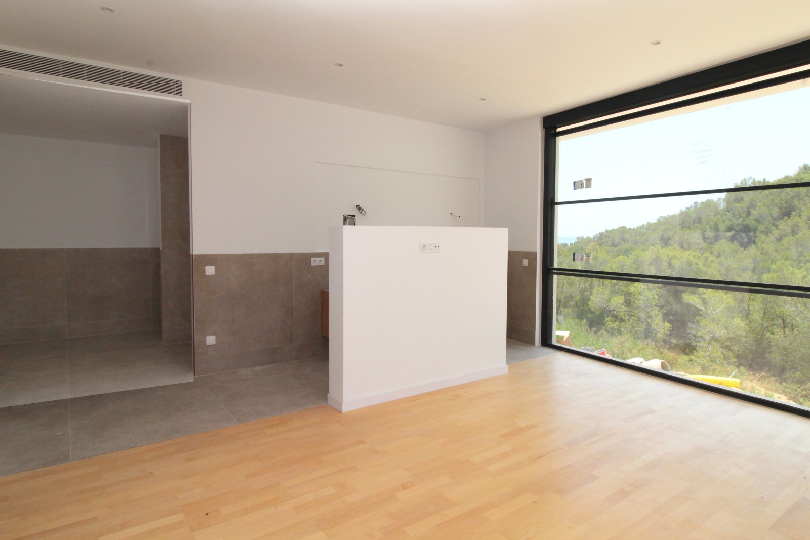 Offenes Wohnzimmer mit raumhohen Panoramafenstern und Waldblick Offenes Wohnzimmer mit raumhohen Panoramafenstern und Waldblick