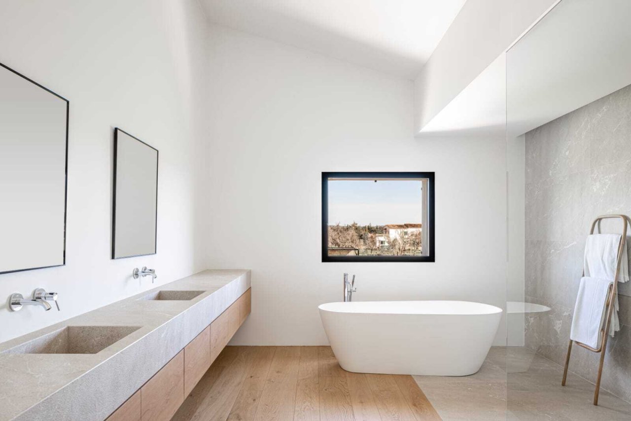 Spa-Atmosphäre mit freistehender Badewanne, Doppelwaschtisch und Panoramafenster zum Landblick Spa-Atmosphäre mit freistehender Badewanne, Doppelwaschtisch und Panoramafenster zum Landblick