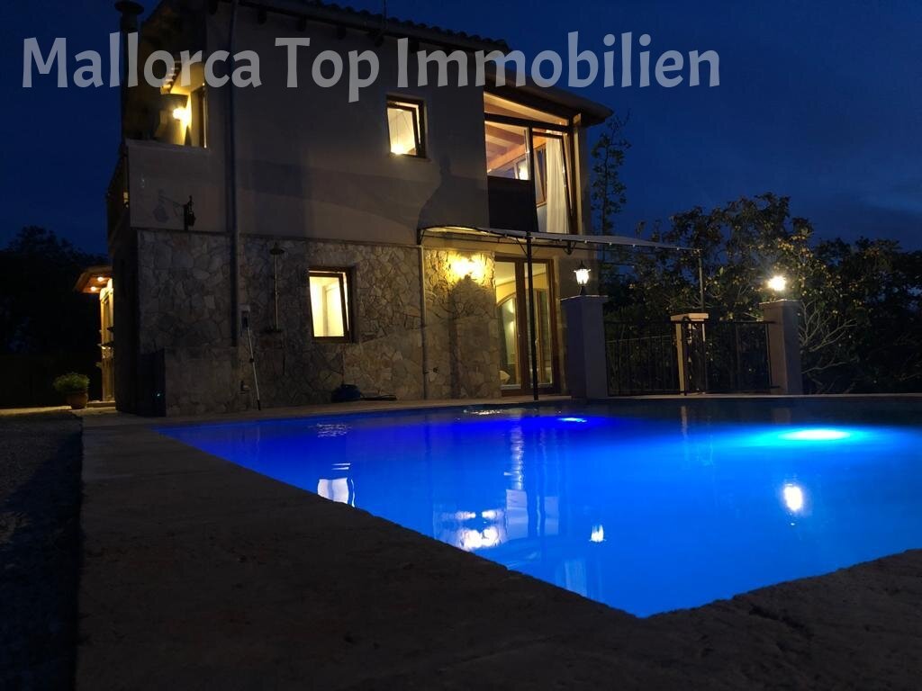 Beleuchteter Pool mit moderner Architektur und entspanntem Außenbereich Beleuchteter Pool mit moderner Architektur und entspanntem Außenbereich