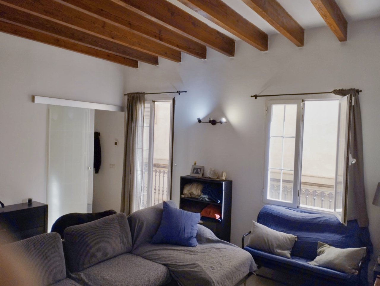 Lichtdurchflutetes Schlafzimmer mit Balkonzugang und rustikalen Holzbalken