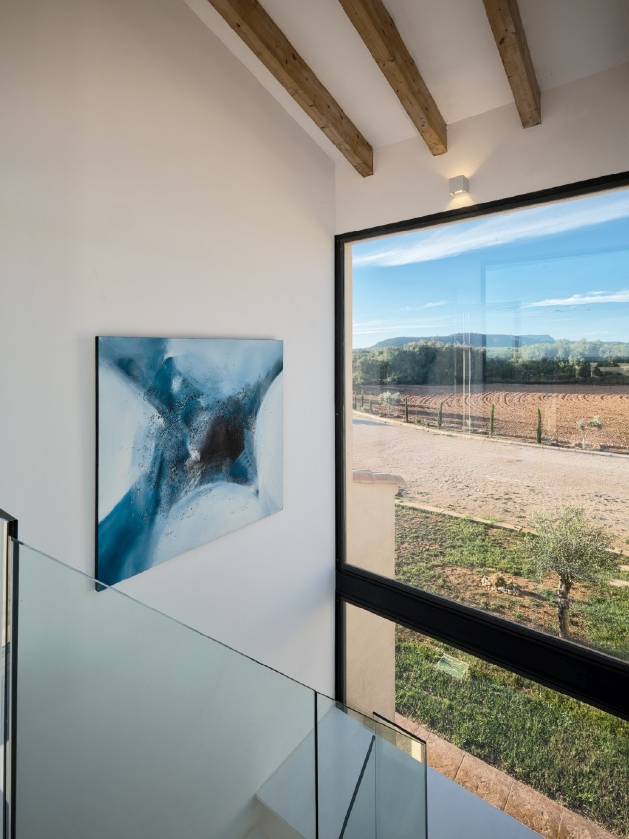 Lichtdurchfluteter Galeriebereich mit Holzbalkendecke und freiem Blick auf die Landschaftskulisse