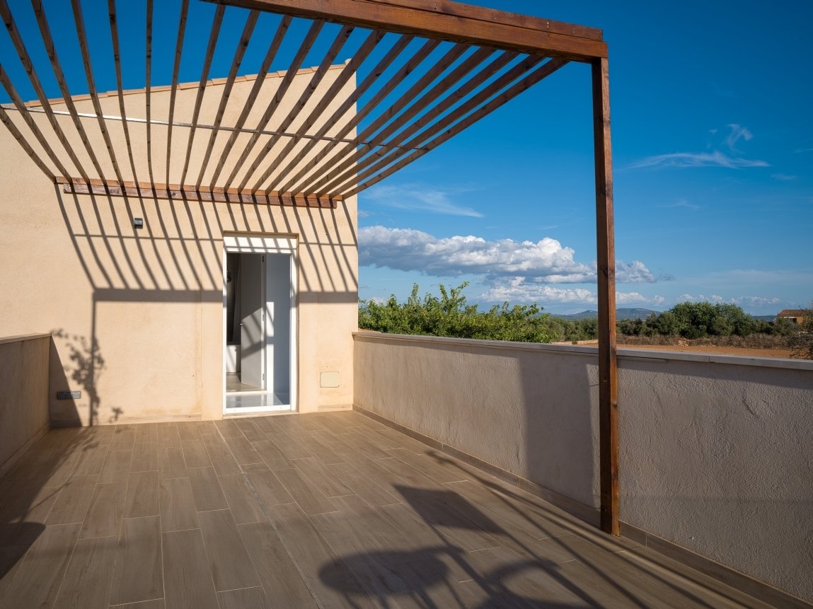 Terrassenbereich mit motorisierter Lamellenbeschattung und Panoramablick auf die Landschaft