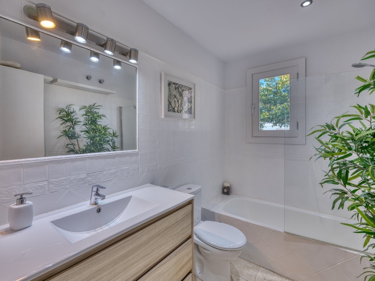 Modernes Badezimmer mit bodengleicher Dusche, Doppelwaschtisch und Fensterblick ins Grüne