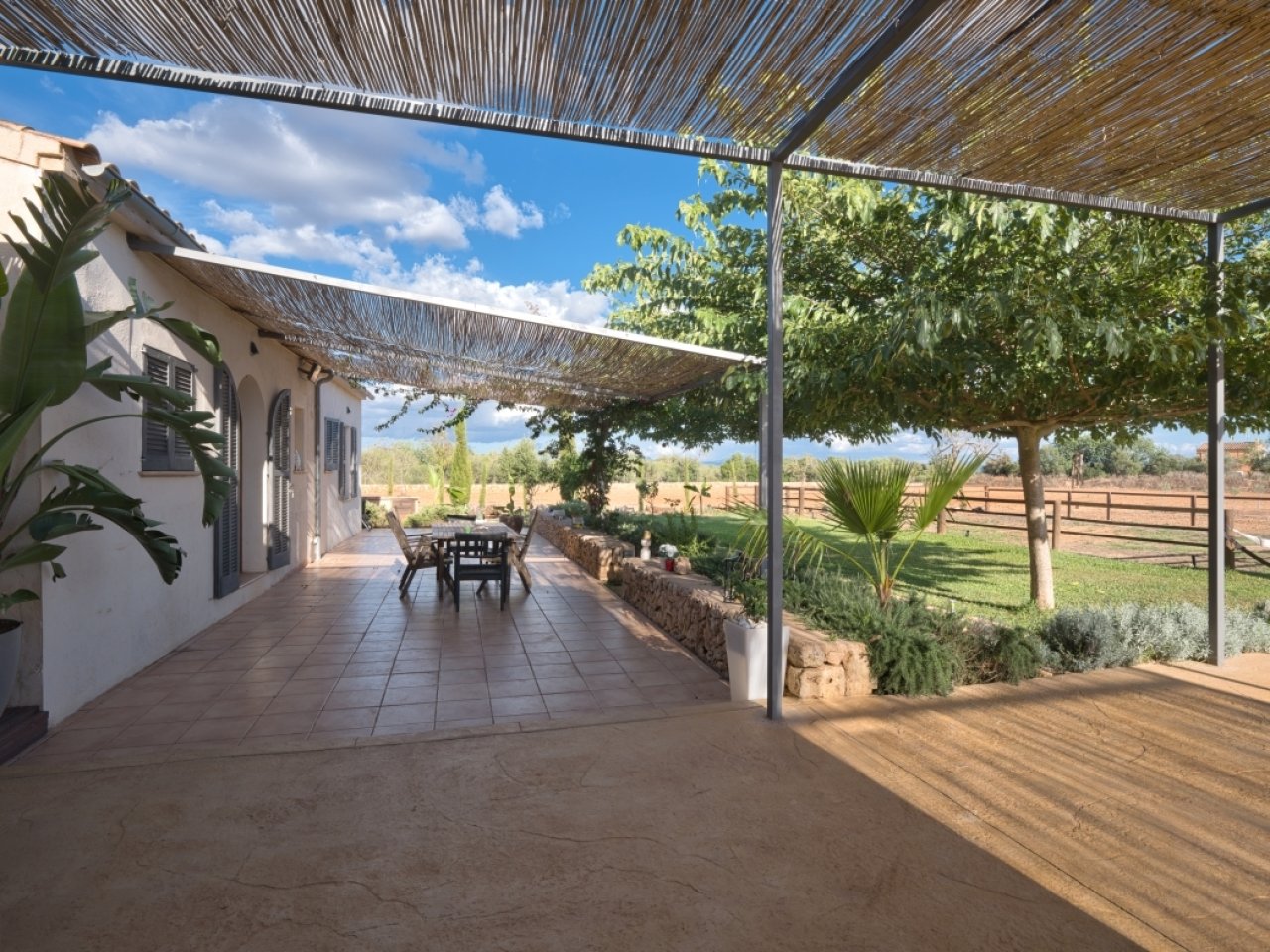 Überdachte Terrasse mit intelligenter Beschattungslösung und Blick auf die Landgüter