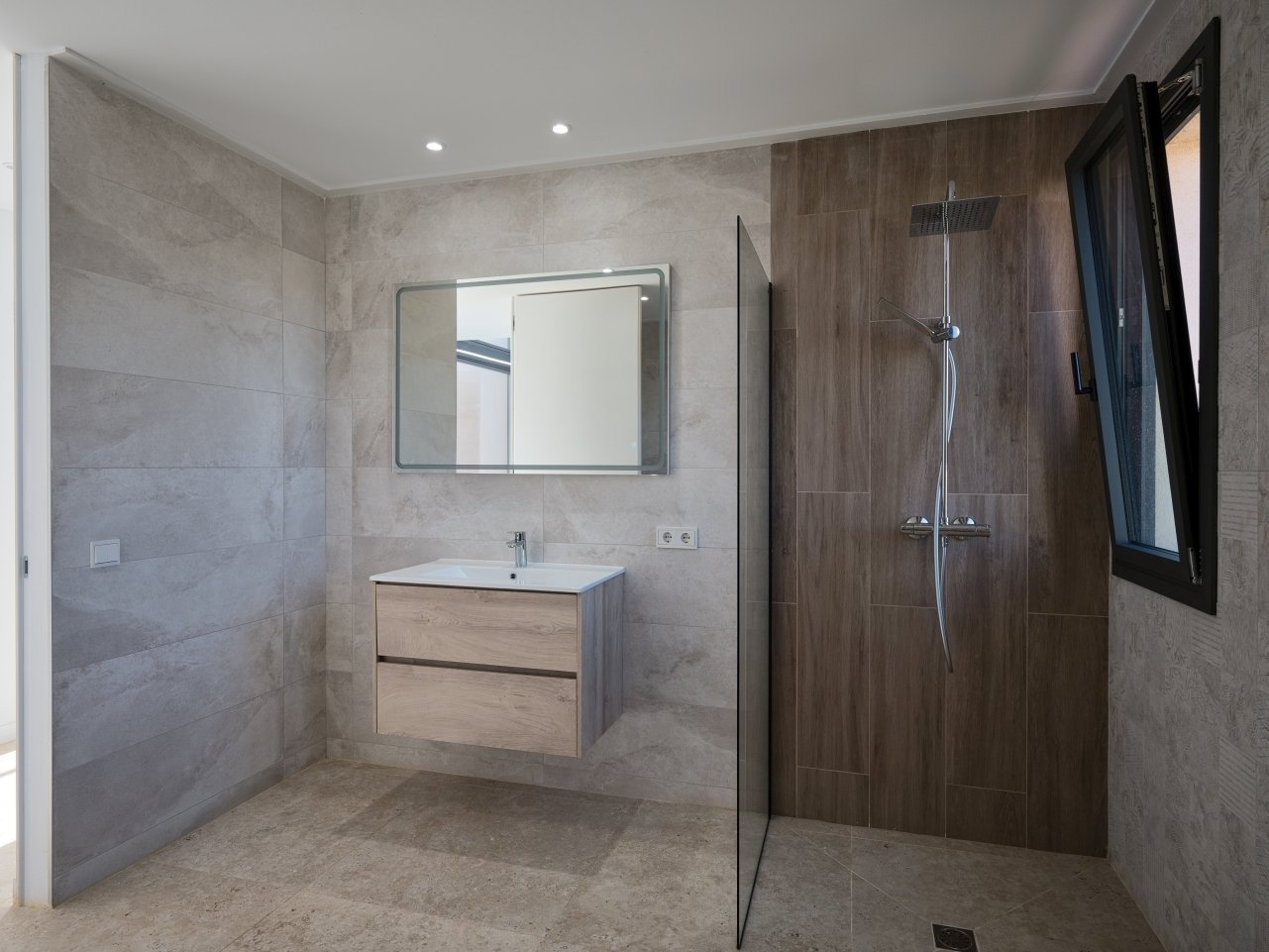 Modernes Badezimmer mit bodengleicher Dusche, Waschtisch mit Stauraum und hochwertiger Ausstattung