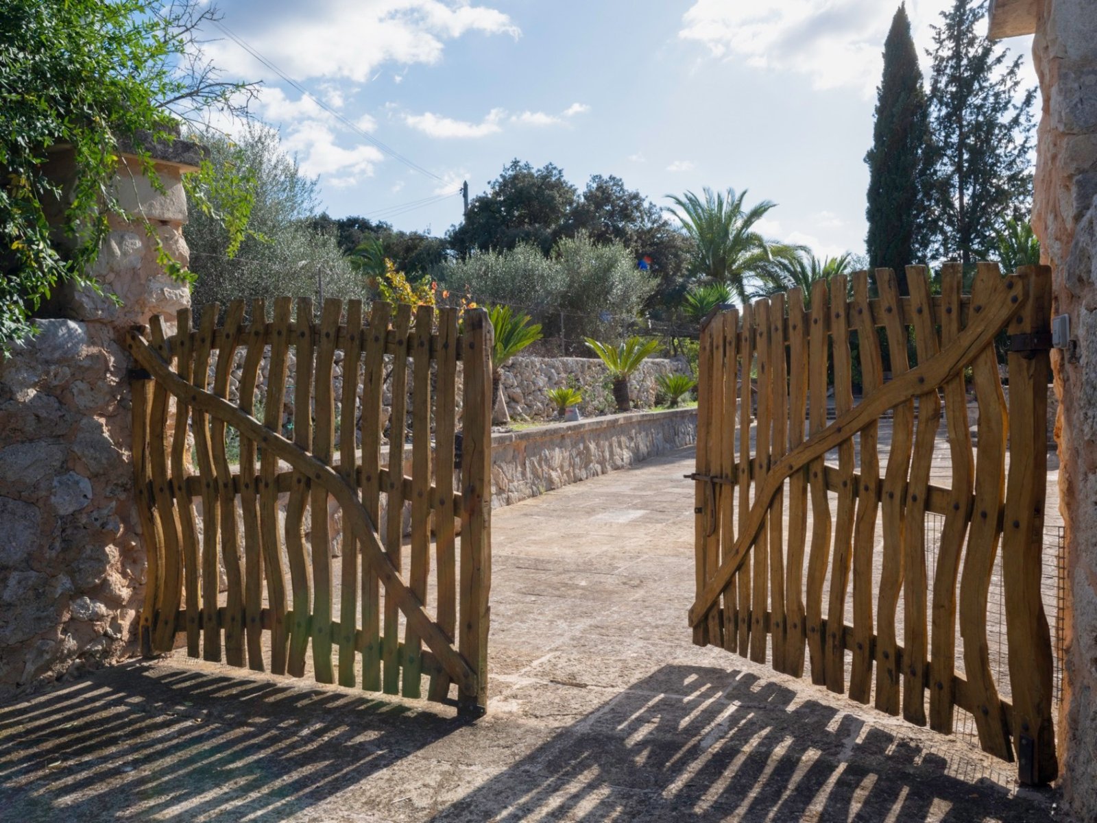 Romantische Toreinfahrt mit massiven Natursteinpfeilern und charaktervollem Holztor Romantische Toreinfahrt mit massiven Natursteinpfeilern und charaktervollem Holztor