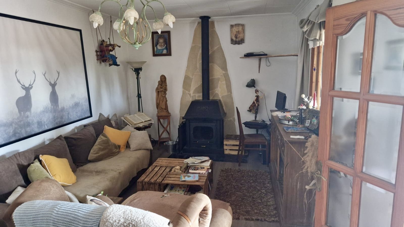 Gemütliches Wohnzimmer mit Kaminofen und direktem Zugang zur Terrasse