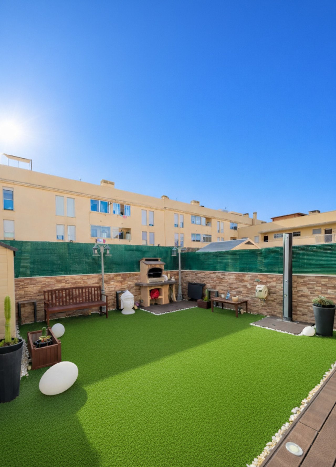 Großzügige Terrasse mit hochwertiger Kunstrasenanlage und Sichtschutz