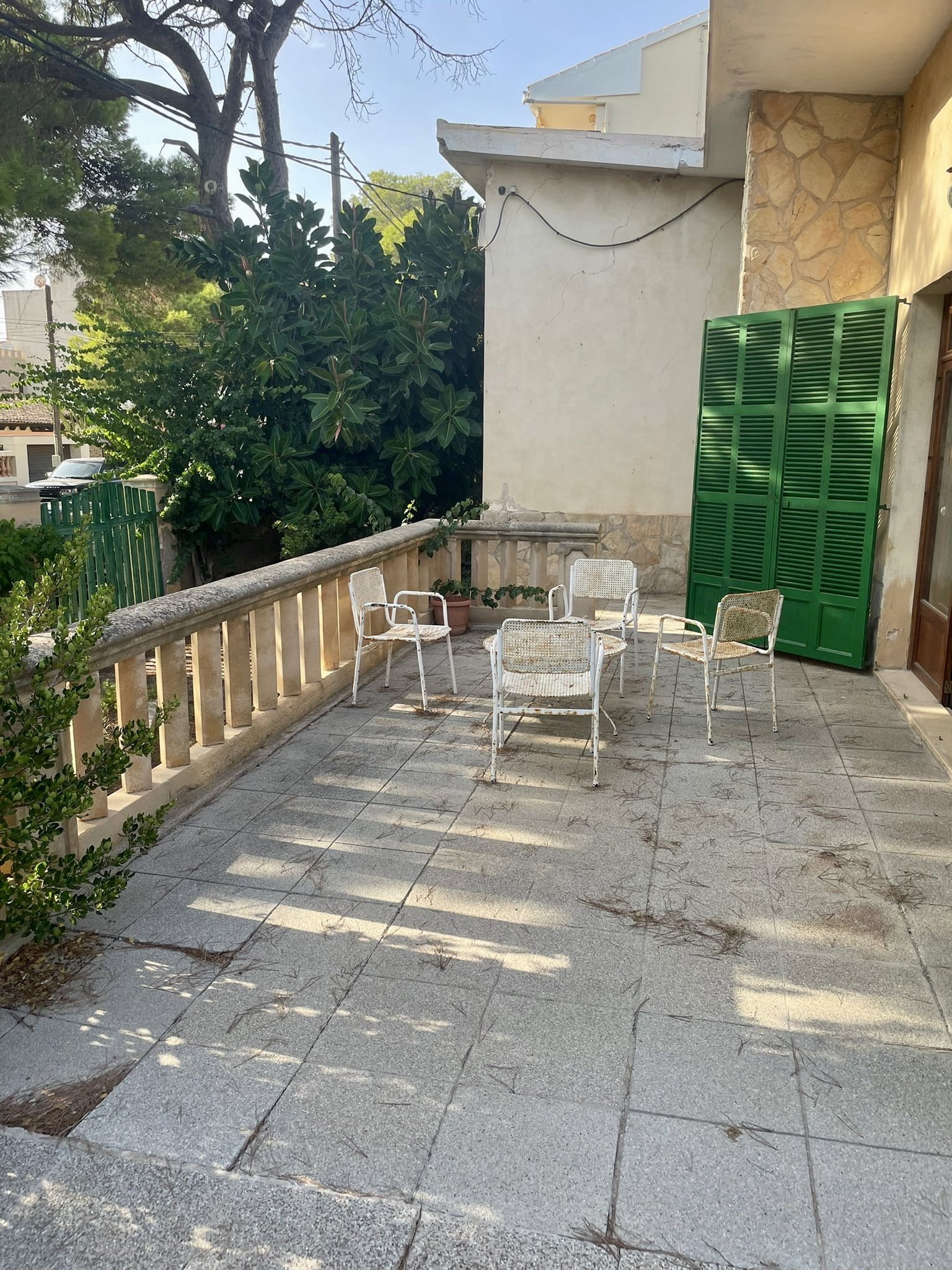Sonnendurchflutete Terrasse mit robustem Natursteinbelag und geschütztem Außenbereich Sonnendurchflutete Terrasse mit robustem Natursteinbelag und geschütztem Außenbereich